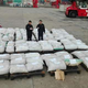 Customs officers stand guard over seized pangolin scales at a port in Shanghai. (Image: AFP/CCTV)
